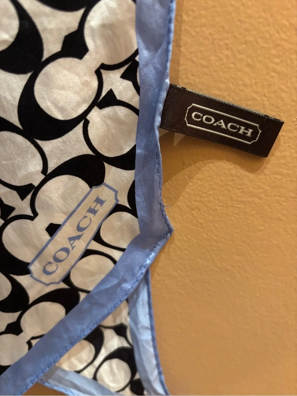 Coach scarf features the signature monogram print in black and white with light